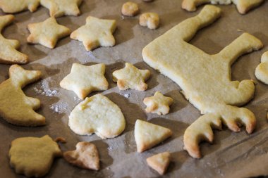 Pişirme tepsisindeki tatlı kısa hamurdan yapılmış basit Noel bisküvileri.