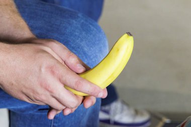 Kafkas Çocuk eli, sarı, soyulmamış, beyaz bir muz tutuyor.