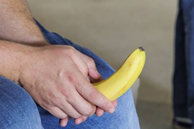 Kafkas Çocuk eli, sarı, soyulmamış, beyaz bir muz tutuyor.