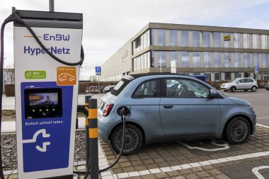 14 Şubat 2024 'te Almanya, Augsburg yakınlarındaki OMV benzin istasyonundaki ENBW hızlı şarj istasyonunda üstü açık mavi Fiat500.