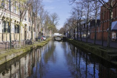 Hollanda 'da Gracht, Delft, 25.3.2024 adlı bir şehir kanalında evleri olan bir sokakta bahar mevsimi.