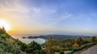 Denizin üzerinde gün batımı ve Korfu adasındaki Agios Georgios Körfezi.