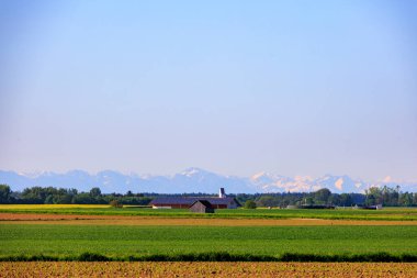Bavyera 'daki Weil köyünün yakınındaki Alpler' in manzarası Untermuhlhausen 'deki St. Benedict Kilisesi' nin kulesiyle birlikte.