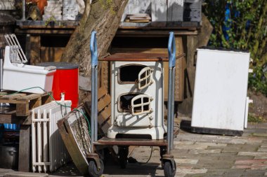 Eski bir odun sobası, bir tramvayda büyük atıkların arasında duruyor.