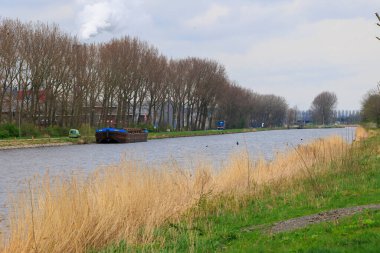 Hollanda 'nın Kuzey Hollanda Kanalı' ndaki sanayi bölgesi ve nakliye gemisi Alkmaar, 27.3.2024