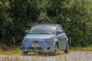 Mavi Fiat 500, Saint Joseph Kilisesi 'nin otoparkında ve Almanya' da Kutsal Adolph Kolping, Bobingen, 20.6.2024