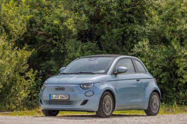 Mavi Fiat 500, Saint Joseph Kilisesi 'nin otoparkında ve Almanya' da Kutsal Adolph Kolping, Bobingen, 20.6.2024