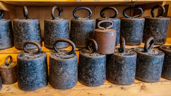 stock image Iron weights for pressing Edam cheese balls sorted into a rack with a banderole with the text Edam in the Netherlands, Edam, 27 March 2024