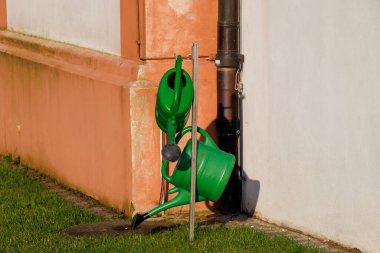 Bavyera 'daki Puch kasabasının mezarlığında iki yeşil plastik sulama kutusuyla ayakta durun.