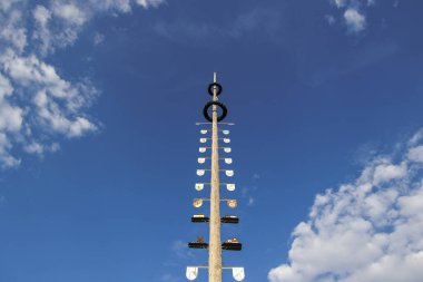 Mavi gökyüzünde, Bavyera 'nın Puch kasabasında küçük beyaz bulutları olan geleneksel bir Bavyera mayıs direği kuleleri