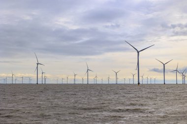 IJsselmeer ile Wadden Denizi, Hollanda, Breezanddijk, 29 / 03 / 2024 arasındaki Afsluitdijk 'te dinlenme alanı yakınlarındaki açık deniz rüzgar çiftliği