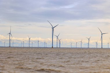 IJsselmeer ile Wadden Denizi, Hollanda, Breezanddijk, 29 / 03 / 2024 arasındaki Afsluitdijk 'te dinlenme alanı yakınlarındaki açık deniz rüzgar çiftliği