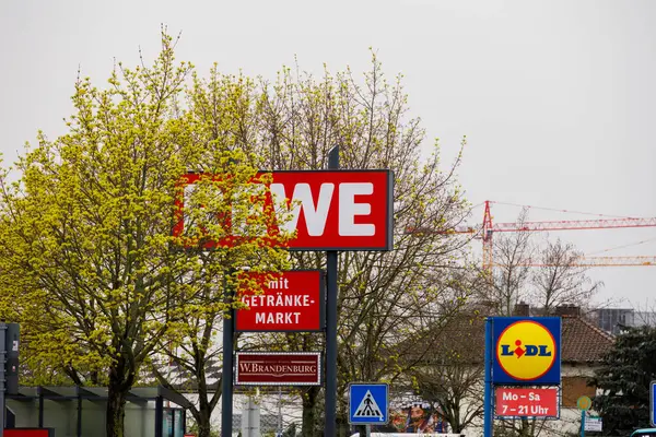 stock image Company signs for Rewe, Lidl and w.Brandenburg German text with beverage store at a shopping centre in Germany, Frankfurt am Main, 30.3.2024