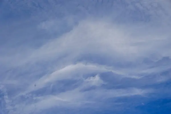 stock image Blue sky with light feathery clouds and the contrails of aeroplanes