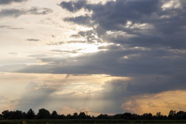Bulutlu bir gökyüzünde Konigsbrunn yakınlarındaki tarlaların üzerinde gün batımı