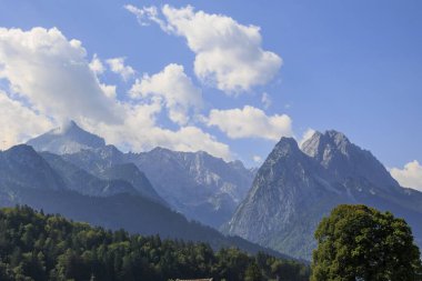Alpspitze ve Zugspitz kalabalığı Wetterstein dağlarında. Güneşli bir günde Garmisch-Partenkirchen 'den paraşütçüler görüldü.