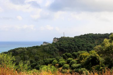 Korfu adasının kuzeyindeki Drastis Burnu 'na kadar uzanan ağaçlık dağları ve zeytin tarlalarını izleyin.