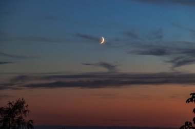 View of a waxing moon in the colourful evening sky from Friedberg towards Augsburg clipart