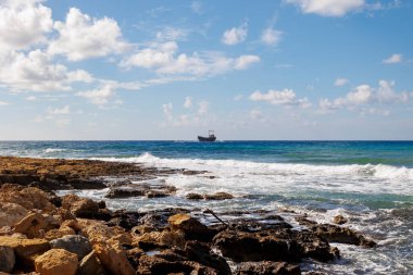 rocky coastline with crashing waves on the island of Cyprus near the shipwreck of the MV Dimitrios II at  city of Paphos in Greece in November clipart