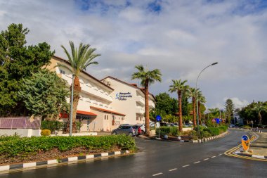 Yunanistan 'daki Paphos Neapolis Üniversitesi boyunca sağanak yağış sonrasında kenarlarında palmiye ağaçları bulunan bir yol, paphos, 18.11.2024