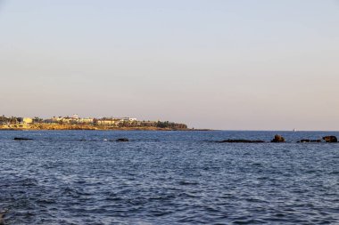 Paphos 'un kayalık kıyı manzarası ve gün batımında binalar, Paphos, Kıbrıs, 23.11.2024.