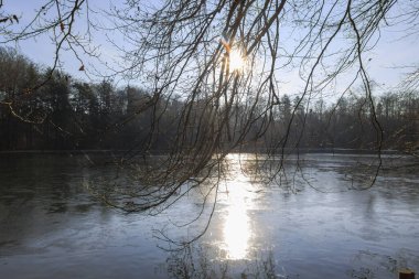 Güneş ışığı, donmuş Stempflesee, Augsburg, Almanya 19 Şubat 2025 'te yansıyor.