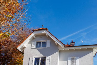 Sonbaharda beyaz panjurlu geleneksel Bavyera evi, Almanya, Riederau, 01.11.2024