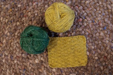 Yünlü halıya örülmüş yeşil ve sarı keten iplik.