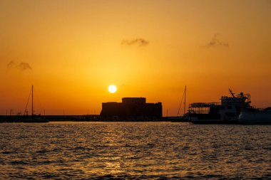 Paphos Kalesi ve limanı üzerinde altın gün batımı, Kıbrıs, 23.11.2024