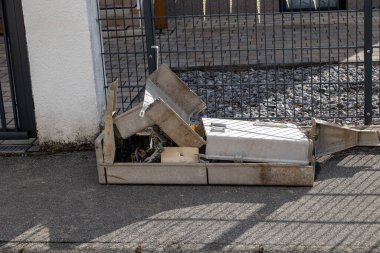 Kaldırımda parçalanmış ve atılmış elektrik kabini bileşenleri