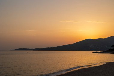 Ajaccio Fransa, Korsika, Ajaccio, 13 Haziran 2025 'te kumlu sahilde altın gün batımı