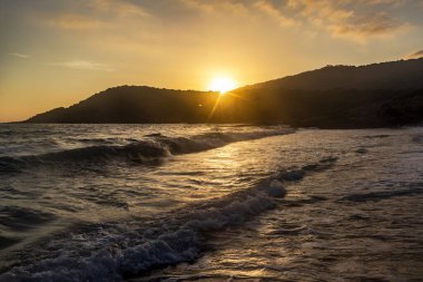 Dalgalar ve dağ siluetiyle gün batımı, Yunanistan, Korfu, 17 Haziran 2025