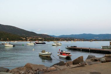 17 Haziran 2025 'te Fransa Korsika' da arka planda dağlarla limana demir atmış tekneler.