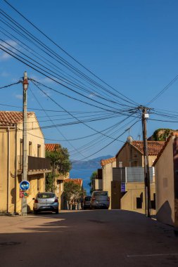 Terracotta çatısı olan elektrik hatları ve evler Fransa, Korsika, Cargse, 18 Haziran 2025
