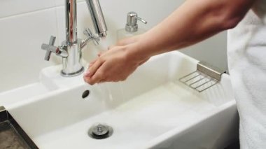 Kadınlar banyo lavabosunda ellerini yıkıyor.