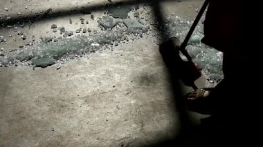 Kırık camları yerden süpüren kişi