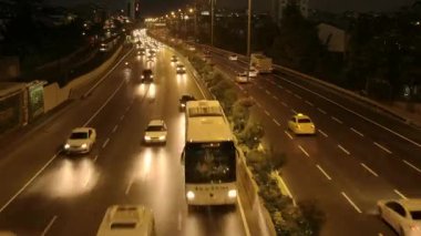 Gece geniş bir caddede akan trafik.
