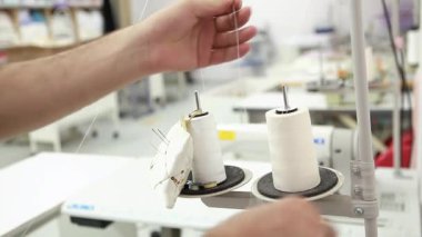  Dikiş makinesinin ipliğini değiştiren kişi.
