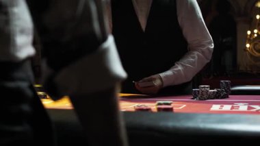 Yaklaştın. Takım elbiseli adam cips oynuyor.