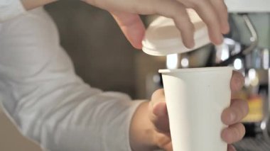 Barista bir espressonun kapağını kapatıyor..