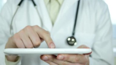  Doktor parmaklarıyla tableti kullanıyor.