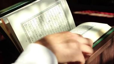 Kuran 'ın sayfalarına bakan dindar bir adam.