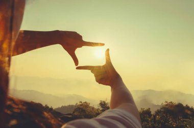 close up hand framing looking view sunrise