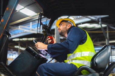 Forklift sürücüsü profesyonel kargo taşımacılığı iletişimi için radyodan konuşuyor.