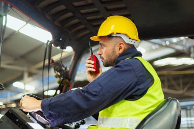 Forklift sürücüsü profesyonel kargo taşımacılığı iletişimi için radyodan konuşuyor.