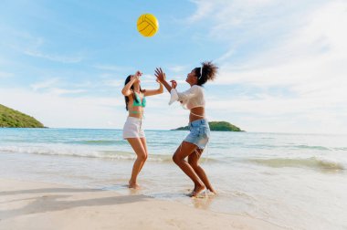 Kumsalda top oynayan güzel bir kadın.