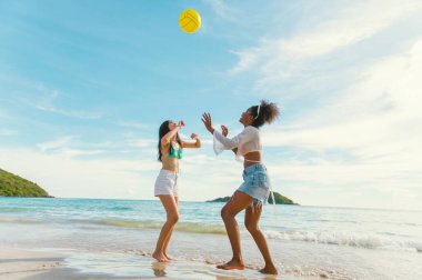 Kumsalda top oynayan güzel bir kadın.