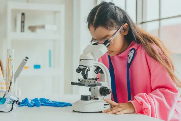 children using microscopes to study science at school