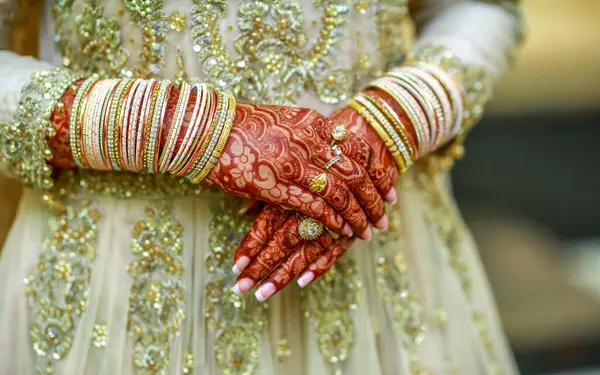 Indian Bride Wearing White Dress with Beautiful Henna on her hands with bangles on her Valima Ceremony