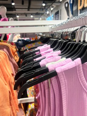 Erkekler ve kadınlar için yaz kıyafetleri kazaklar gömlekler gömlekler gömlekler formalar ceketler mağazadaki askıda asılı. pembe elbiseler